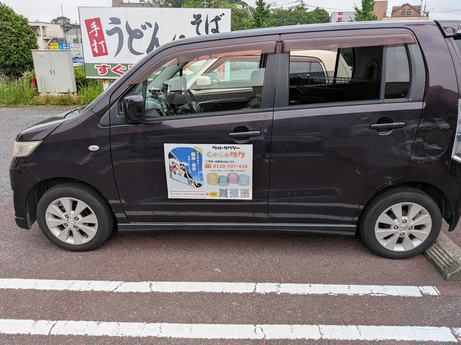 COCOタク北九州小倉店の専用車両。側面にペットタクシーの案内と電話番号0120-597-410を掲示し、後部にペット用ケージを積んでいる